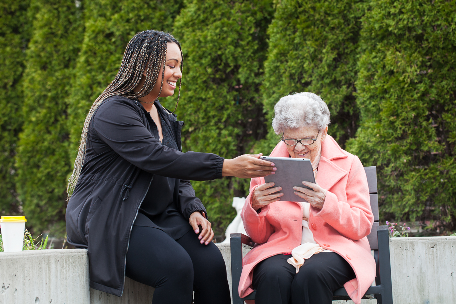 An intervenor hands a tablet to a client with a large print message written on it for them to read.