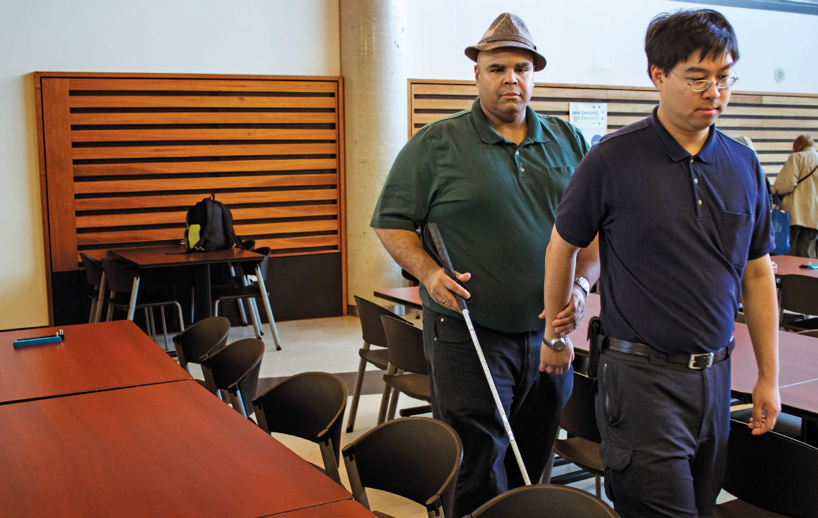 A person provides a sighted guide to an individual with sight loss.