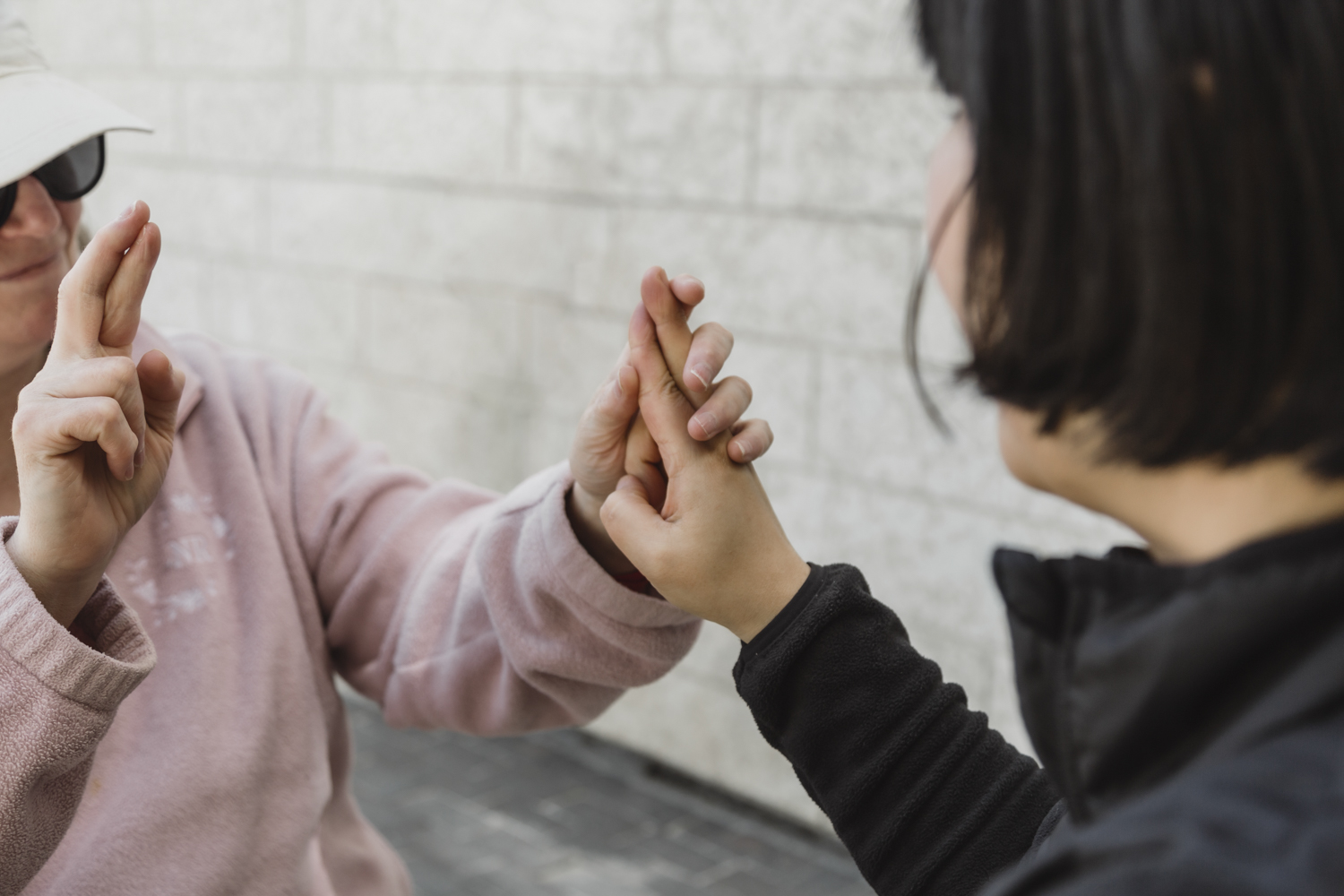 An intervenor demonstrates how tactile ASL works with a client. The signer communicates using ASL, and the person receiving uses their hands to feel the signs as they are made.