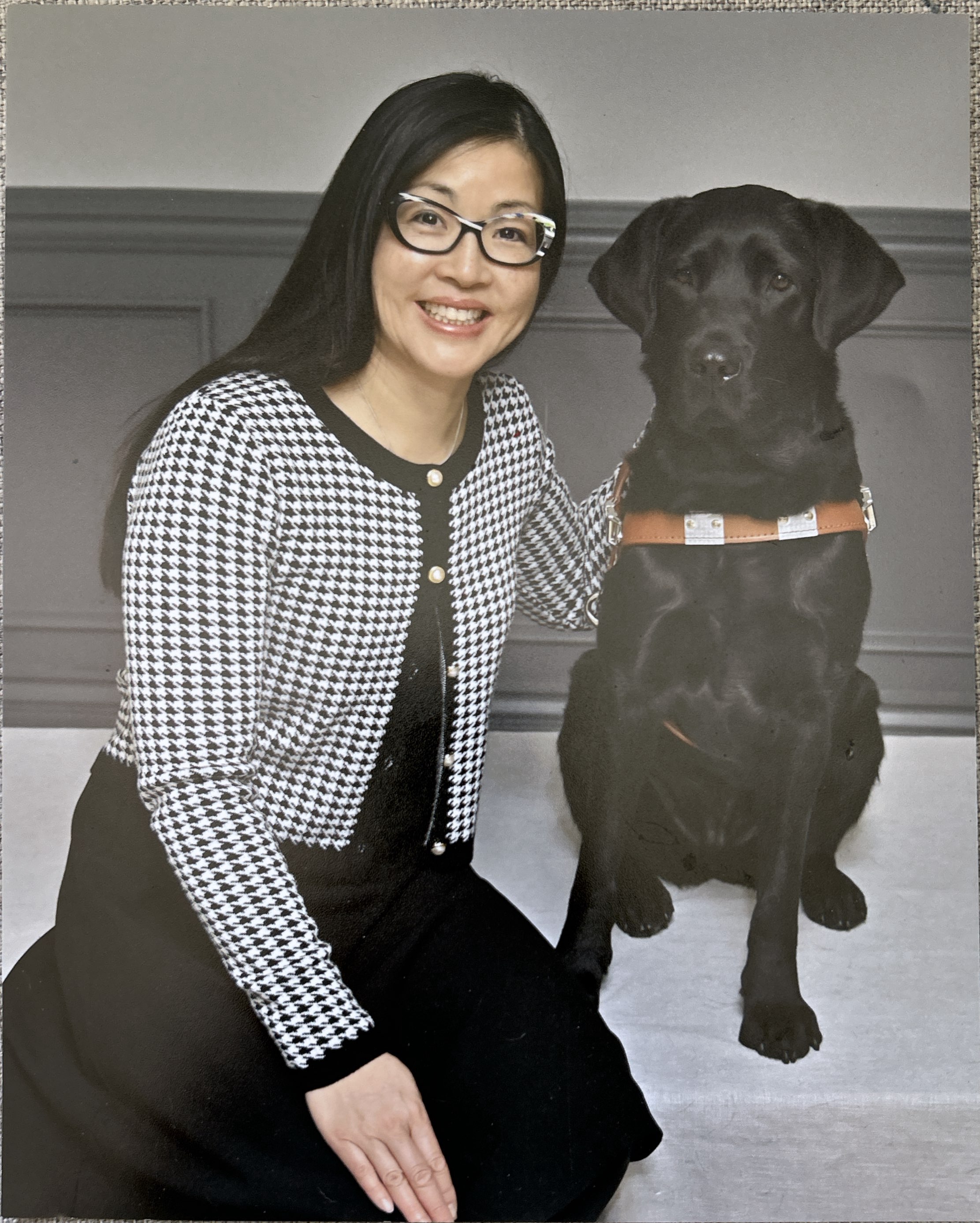 An image of Kathryn Jung sitting beside her black lab guide dog