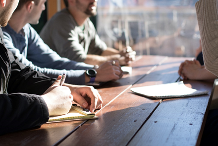 A group of people sit at a table together, talking